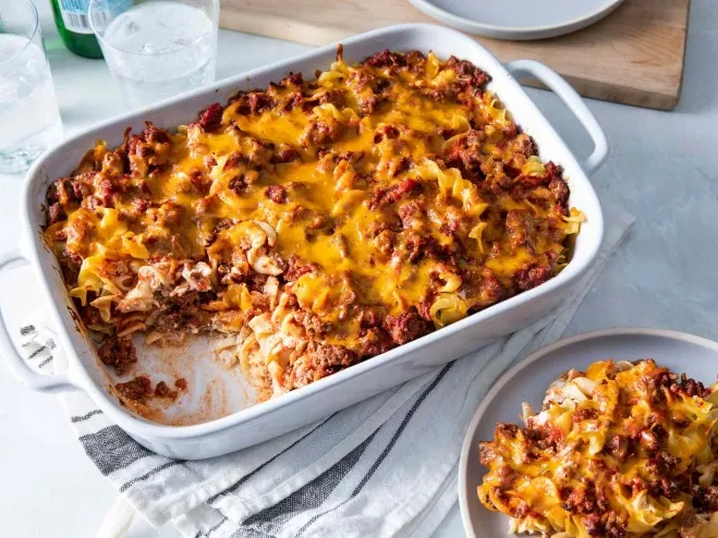 1. A white casserole dish filled with a delicious taco casserole, showcasing layers of meat, cheese, and toppings ground beef