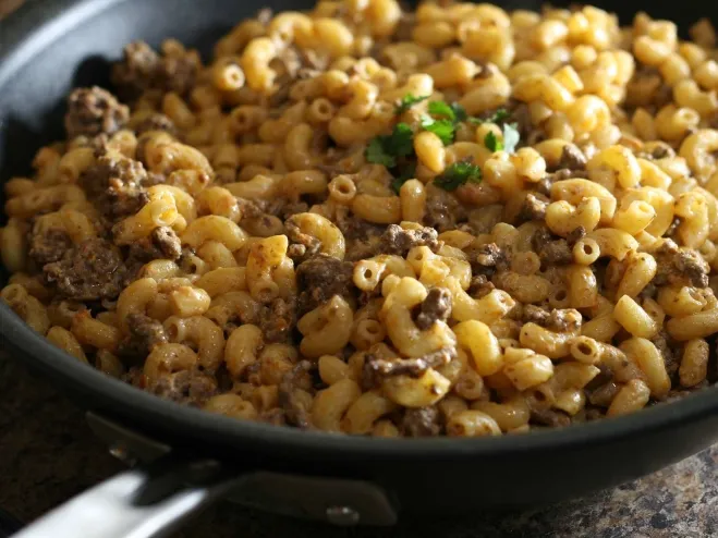 1. A skillet brimming with creamy macaroni and savory meat, showcasing a delicious and hearty meal ready to serverecipes with ground beef in them