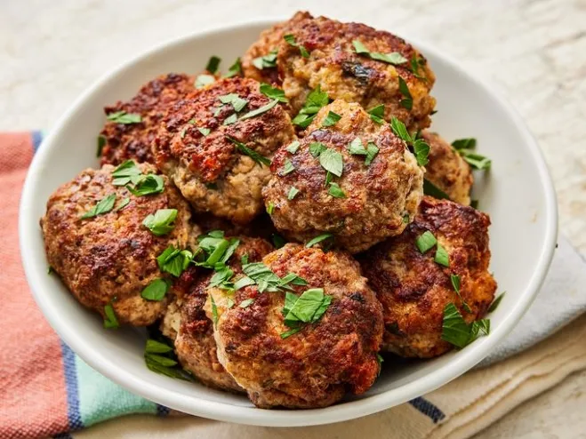 A bowl of meatballs garnished with fresh parsley, showcasing a delicious and appetizing dish ground meat ideas