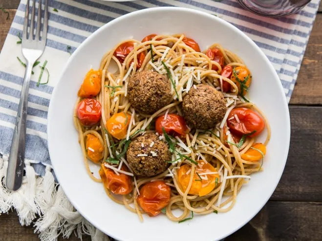  A plate of spaghetti topped with meatballs and garnished with fresh cherry tomatoes, showcasing a delicious Italian dish dinner ideas using ground beef