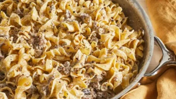 1. A pan of pasta and meat sits on a table, ready to be served, showcasing a delicious meal: dishes made with hamburger