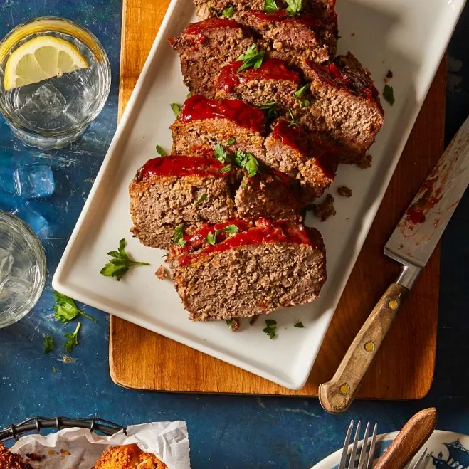 1. A succulent meatloaf topped with barbecue sauce, accompanied by slices of bread, displayed on a wooden cutting boardground mince recipes