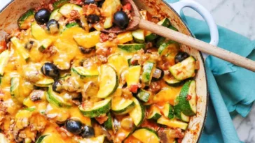 1. A skillet brimming with sautéed zucchini, black olives, and melted cheese, showcasing a vibrant and appetizing dishrecipes with ground beef in them