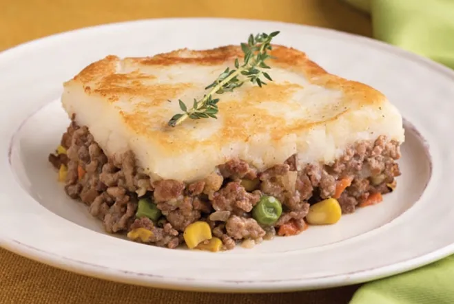 A serving of meat and vegetable casserole presented on a white plate, showcasing a colorful and hearty dish recipes containing ground beef