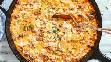 1. A skillet filled with a cheesy egg casserole, showcasing a golden-brown top and a deliciously fluffy interiorfood recipes with hamburger meat