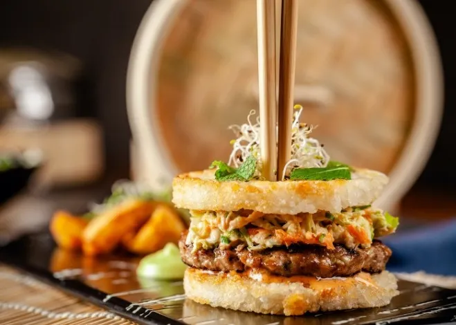 1. A hamburger topped with chopsticks, creatively blending Western and Asian culinary elements in a unique presentationground beef and recipes