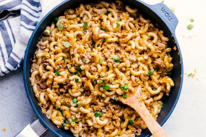 A skillet filled with creamy, cheesy macaroni and cheese, showcasing a golden, bubbly top and a rich, inviting texture recipes containing ground beef