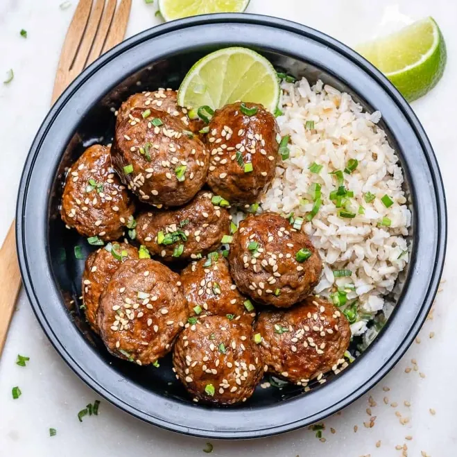 1. A bowl of Asian meatballs served with rice and lime wedges, showcasing a vibrant and appetizing mealfood recipes with hamburger meat