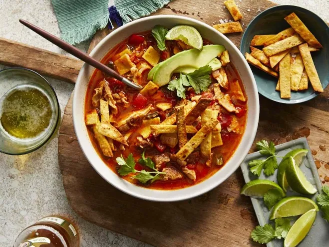 A bowl of chicken tortilla soup garnished with fresh lime and cilantro, showcasing vibrant colors and textures healthy lunch suggestions