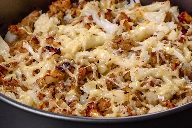 A skillet brimming with sizzling meat and melted cheese, showcasing a delicious and hearty meal ready to be served dinner meals with ground beef