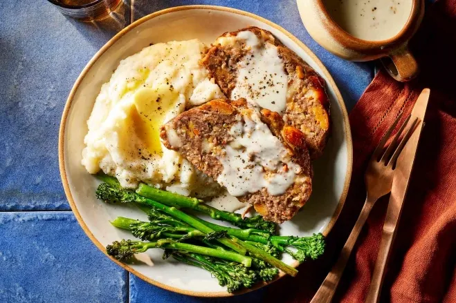 A plate featuring a slice of meatloaf, creamy mashed potatoes, and steamed broccoli, arranged appetizingly ground beef dishes for dinner