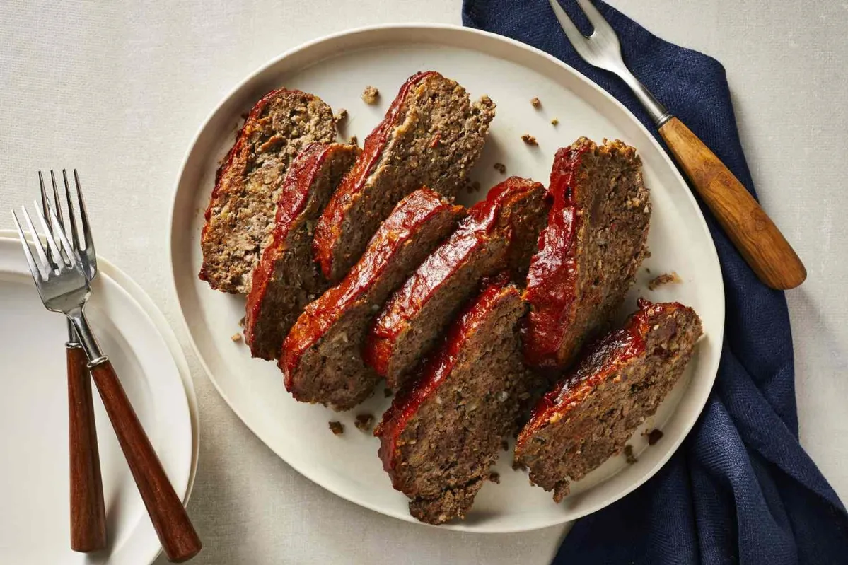 A plate of meatloaf served with a knife and fork, ready to be enjoyed in a cozy dining setting recipes containing ground beef