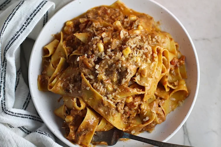 A plate of pasta topped with savory meat and melted cheese, showcasing a delicious Italian dis recipes with ground beef