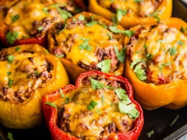 1. A baking dish filled with stuffed peppers, generously topped with cheese and filled with savory meat recipes to make with ground beef