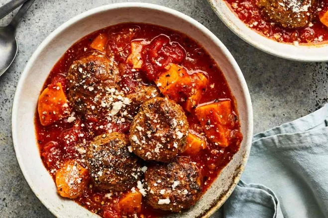 1. A plate of meatballs and sweet potatoes simmered in rich tomato sauce, garnished with herbs for added flavorbeef ground meat recipes