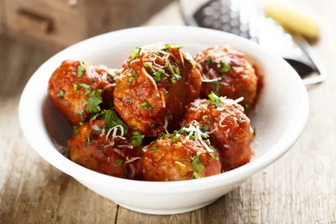 1. A bowl filled with meatballs topped with rich sauce and sprinkled with grated parmesan cheesebeef ground meat recipes