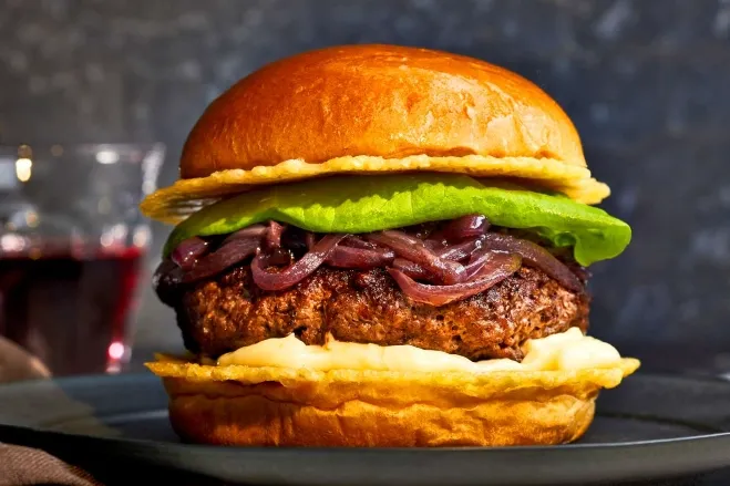  A delicious hamburger topped with onions and melted cheese, served on a plate, ready to be enjoyed hamburger dishes for supper