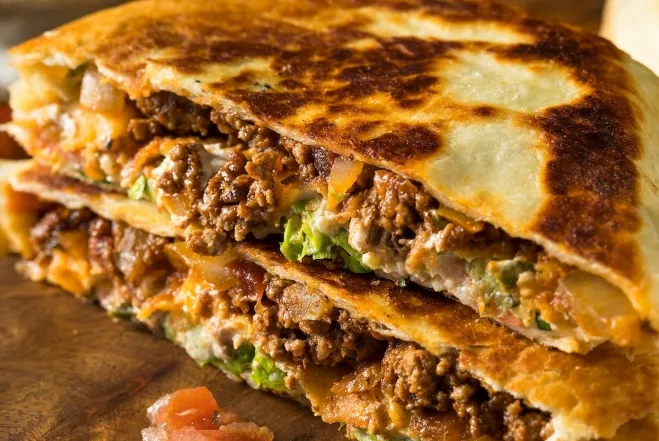 dinner ideas using ground beef A close-up view of a quesadilla filled with savory meat and melted cheese, showcasing its delicious texture and color 