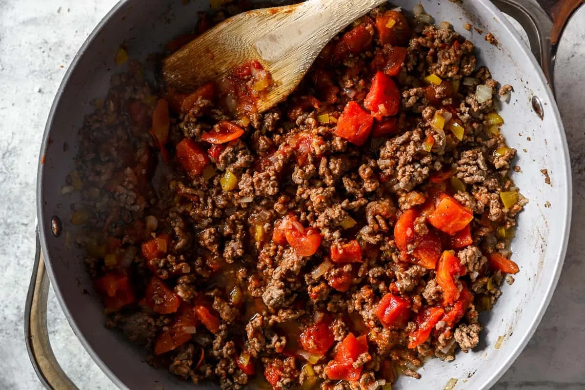 A skillet filled with seasoned ground beef and colorful bell peppers, ready for cooking or serving in a delicious dish hamburger dishes for supper