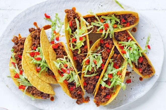 A plate of tacos filled with seasoned meat and fresh vegetables, showcasing a colorful and appetizing arrangement ground beef dinner ideas