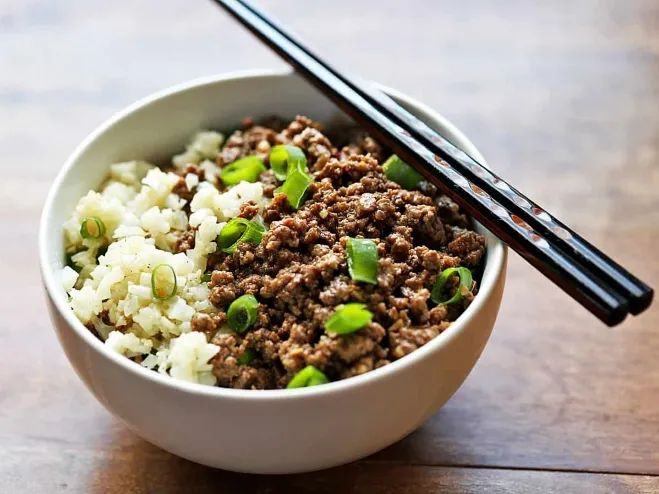 A Korean beef bowl featuring tender beef, rice, and fresh green onions, beautifully presented in a traditional dish ideas with ground beef for dinner