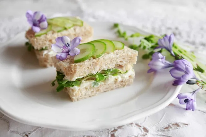 1. A plate featuring two sandwiches accompanied by a decorative arrangement of flowers luncheon ideas