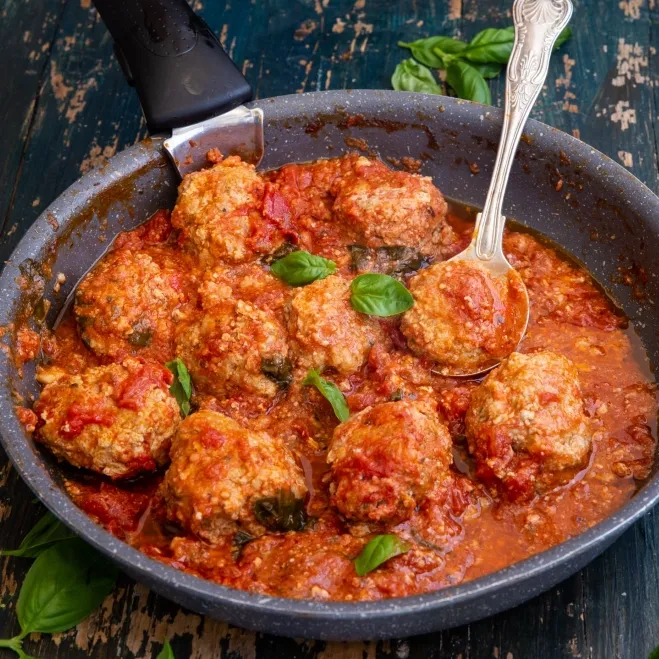 1. A pan filled with Italian meatballs simmering in rich tomato sauce, accompanied by a spoon for servingground mince recipes