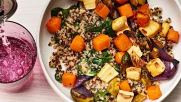 lunchtime ideas A bowl filled with colorful vegetables alongside a refreshing glass of juice on a wooden table