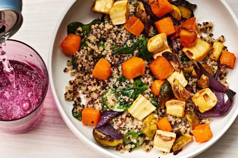 lunchtime ideas A bowl filled with colorful vegetables alongside a refreshing glass of juice on a wooden table