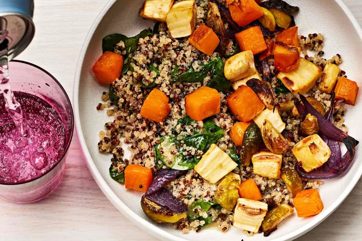 lunchtime ideas A bowl filled with colorful vegetables alongside a refreshing glass of juice on a wooden table