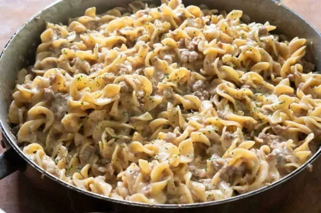  A pan of pasta and meat sits on a table, ready to be served, showcasing a delicious meal recipes made with hamburger meat