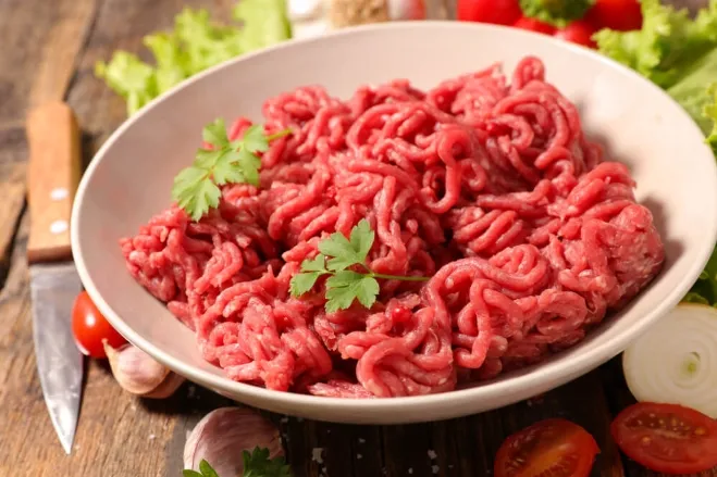 1. A bowl of raw ground beef placed on a wooden table, ideal for various ground beef recipes recipes to make with ground beef