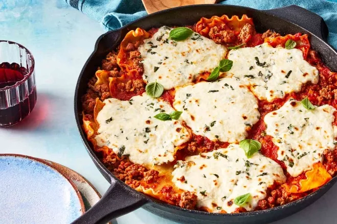 A skillet filled with delicious lasagna, topped with melted cheese, ready to be served hamburger dishes for supper