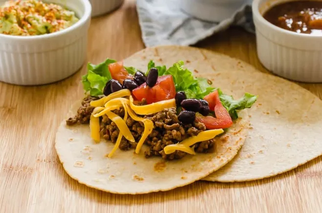  A delicious taco filled with seasoned meat, melted cheese, and black beans, showcasing vibrant colors and textures ground beef dishes for dinner