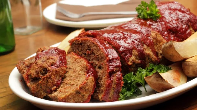 A plate featuring meatloaf topped with gravy, accompanied by a serving of mashed potatoes chop meat dinner ideas